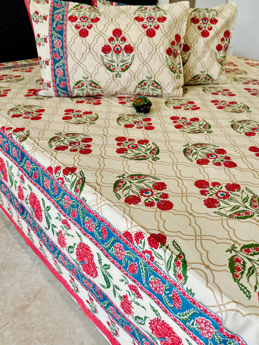 Floral patterned bedspread with matching pillows on a bed, labeled 'Shahi Collection'.