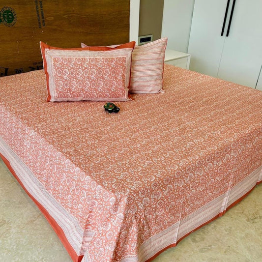Bedspread with rust orange and white pattern on a bed, with 'Shahi Collection' branding.