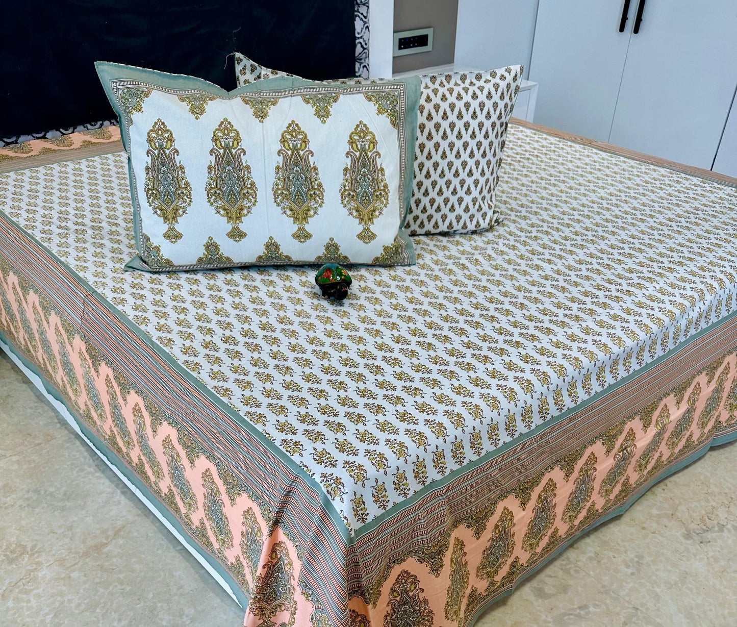 Decorative bedspread with intricate patterns on a bed, featuring the 'Shahi Collection' label.