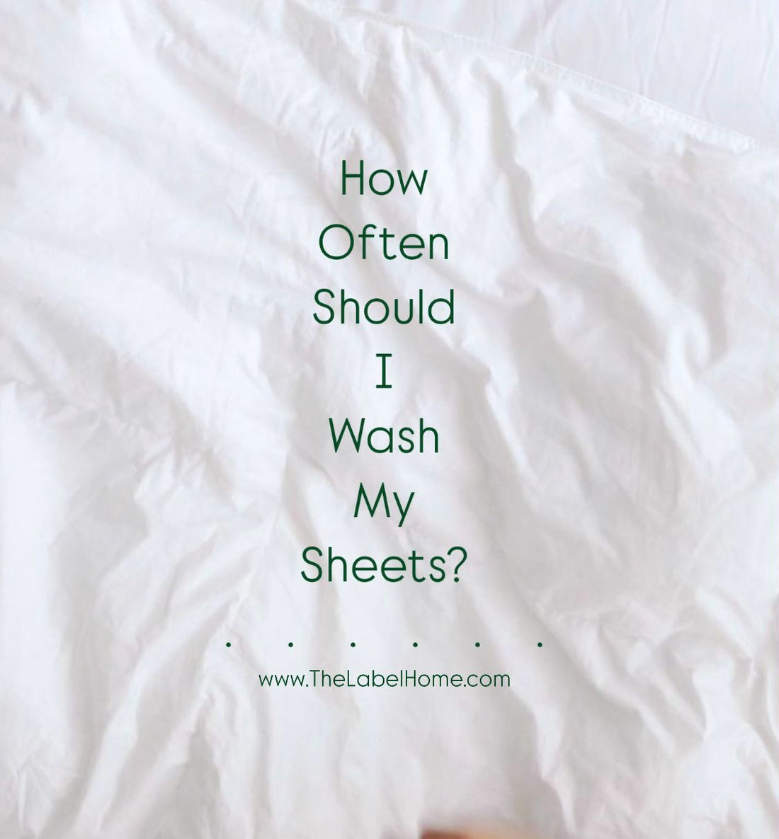 White, slightly crumpled bedsheet with text overlay asking, 'How Often Should I Wash My Sheets?' and The Label Home website link at the bottom.