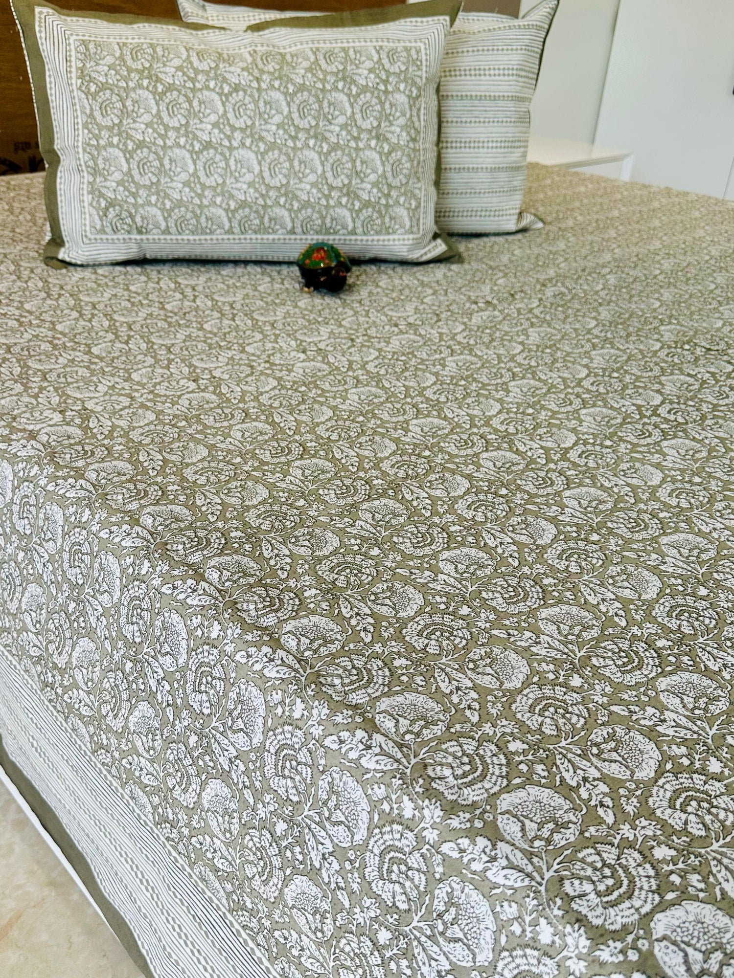 Bedspread with floral pattern on a bed, featuring 'Shahi Collection' branding.