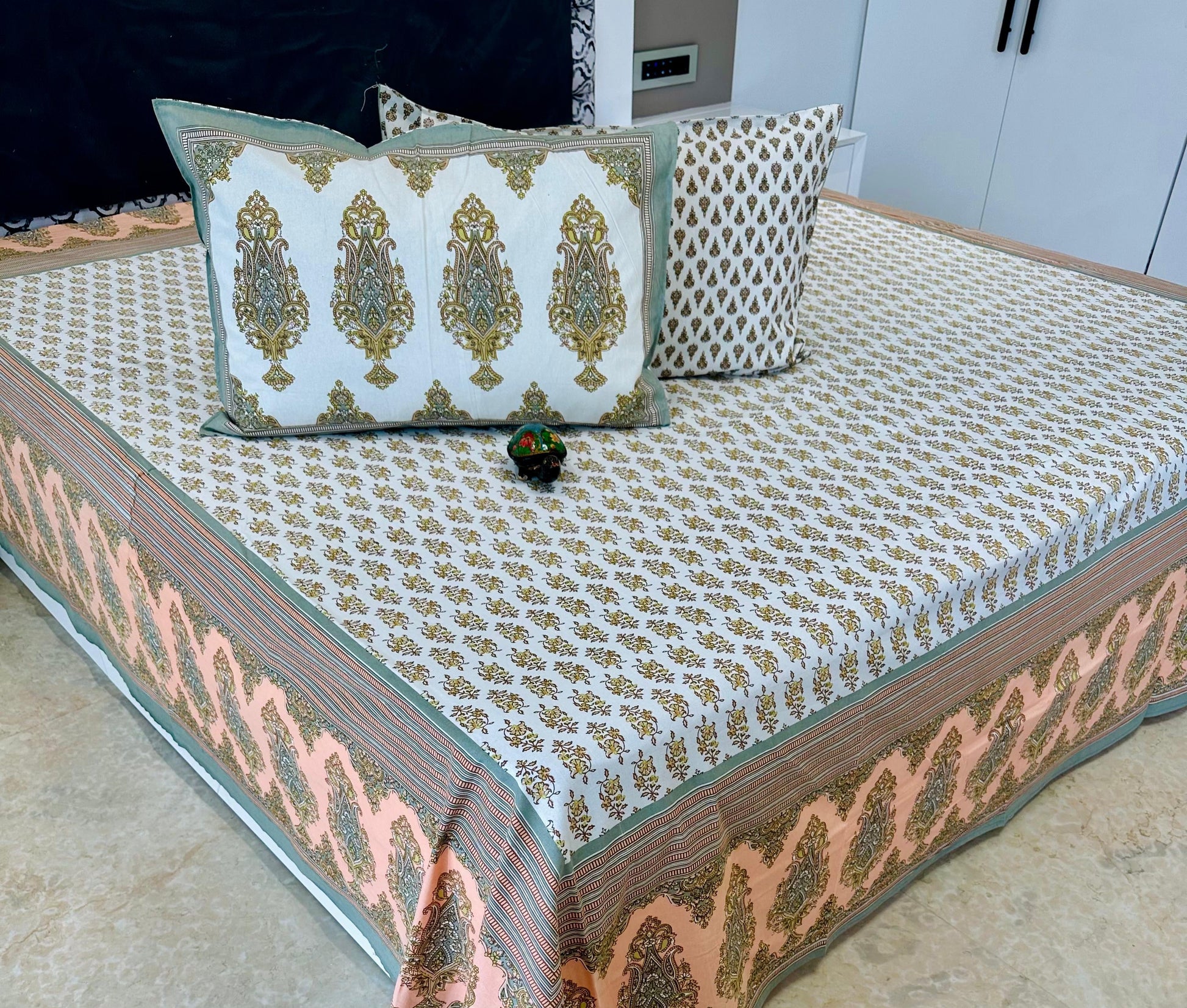 Decorative bedspread with intricate patterns on a bed, featuring the 'Shahi Collection' label.
